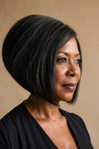 Angled bob with longer front section on thick coarse hair for round face shapes