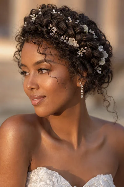 braided bridal crown with crystal pins and flowers tucked into the braid for wedding hairstyles