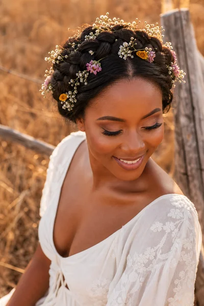 16 Rustic Wedding Hairstyles for Every Hair Length 13 Woman with Dutch braid halo crown adorned with wildflowers and baby's breath, golden-hour field