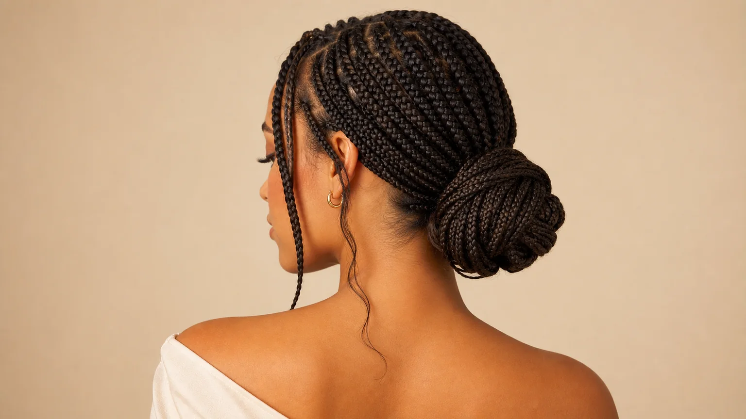 20 Knotless Braids Styles Taking Over 2026 11 Woman with knotless braids gathered into a low, elegant bun updo, showing a formal and professional styling option.