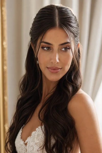 Sleek half-up wedding hairstyle with center part and waves — polished bridal look for oval and long face shapes