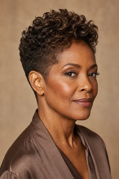 Woman over 50 with a tapered pixie cut showing longer textured crown and short tapered sides from three-quarter view