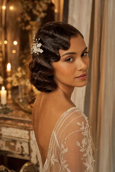 16 Rustic Wedding Hairstyles for Every Hair Length 11 Woman with classic finger waves pinned close to scalp and flower comb, vintage romantic indoor setting