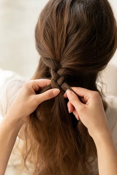 How to braid classic three-strand braid — close-up technique demonstration with hands