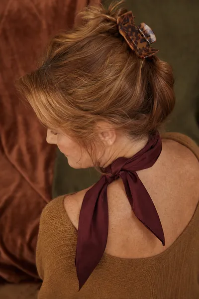 fall hair accessories for women over 50 — tortoiseshell claw clip and silk scarf styling