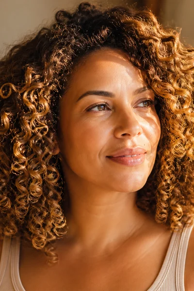 Honey blonde highlights on curly hair — warm gold tones for textured hair