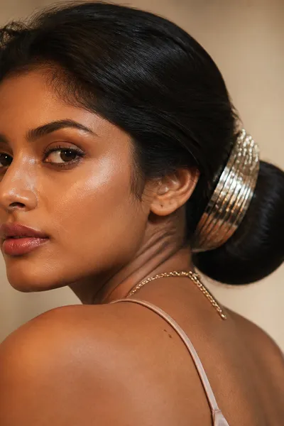 Metallic cuff-wrapped low bun — statement accessory elevates classic bun for prom
