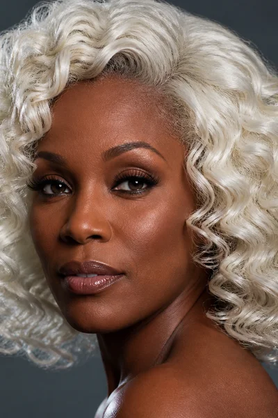 Cool-toned platinum blonde on curly hair — striking cool blonde for textured hair