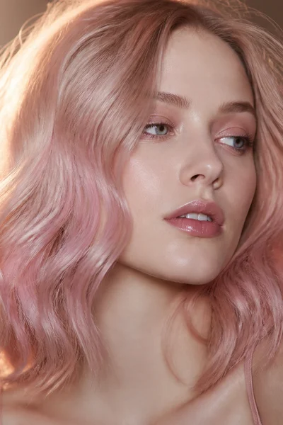 Rose gold delicate pink shimmer on wavy hair — cool-toned subtle blonde color