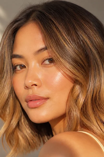 Warm bronde blend on wavy hair — seamless brown-blonde fall color transition