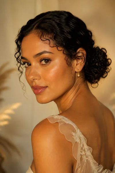 Curly low bun with baby hairs, one of these homecoming hair ideas for curly and textured hair