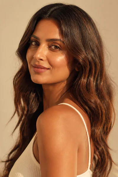 Woman with effortless middle-part waves hairstyle in warm studio lighting