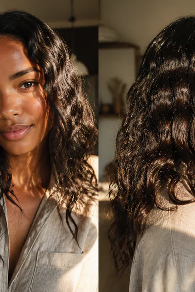 Woman with natural air-dried waves on curly texture in warm golden-hour light